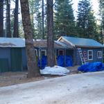 Green metal roof next to old corrugated roofing